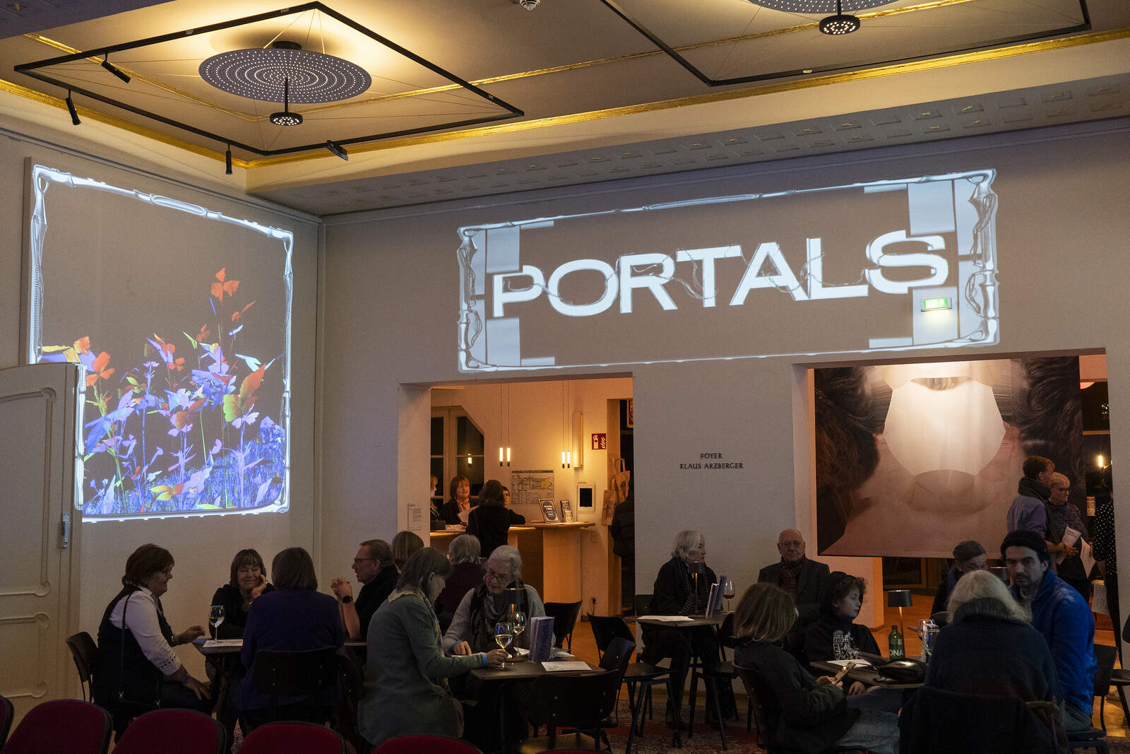 Große Projektion an der Wand, Portals steht als Slogan über zwei Durchgängen 