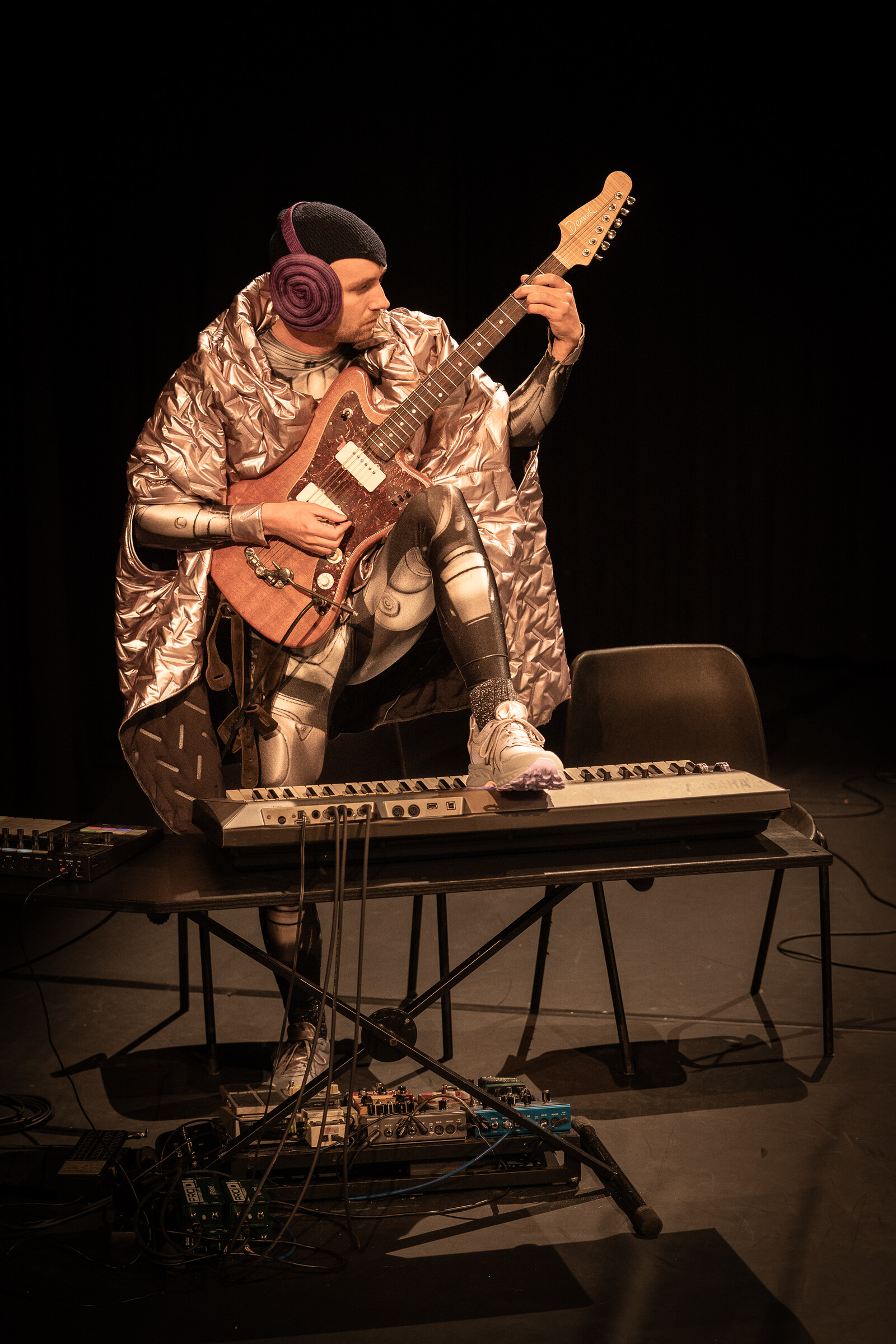 Gitarrenspieler auf einem Tisch, eingepackt in einer Decke