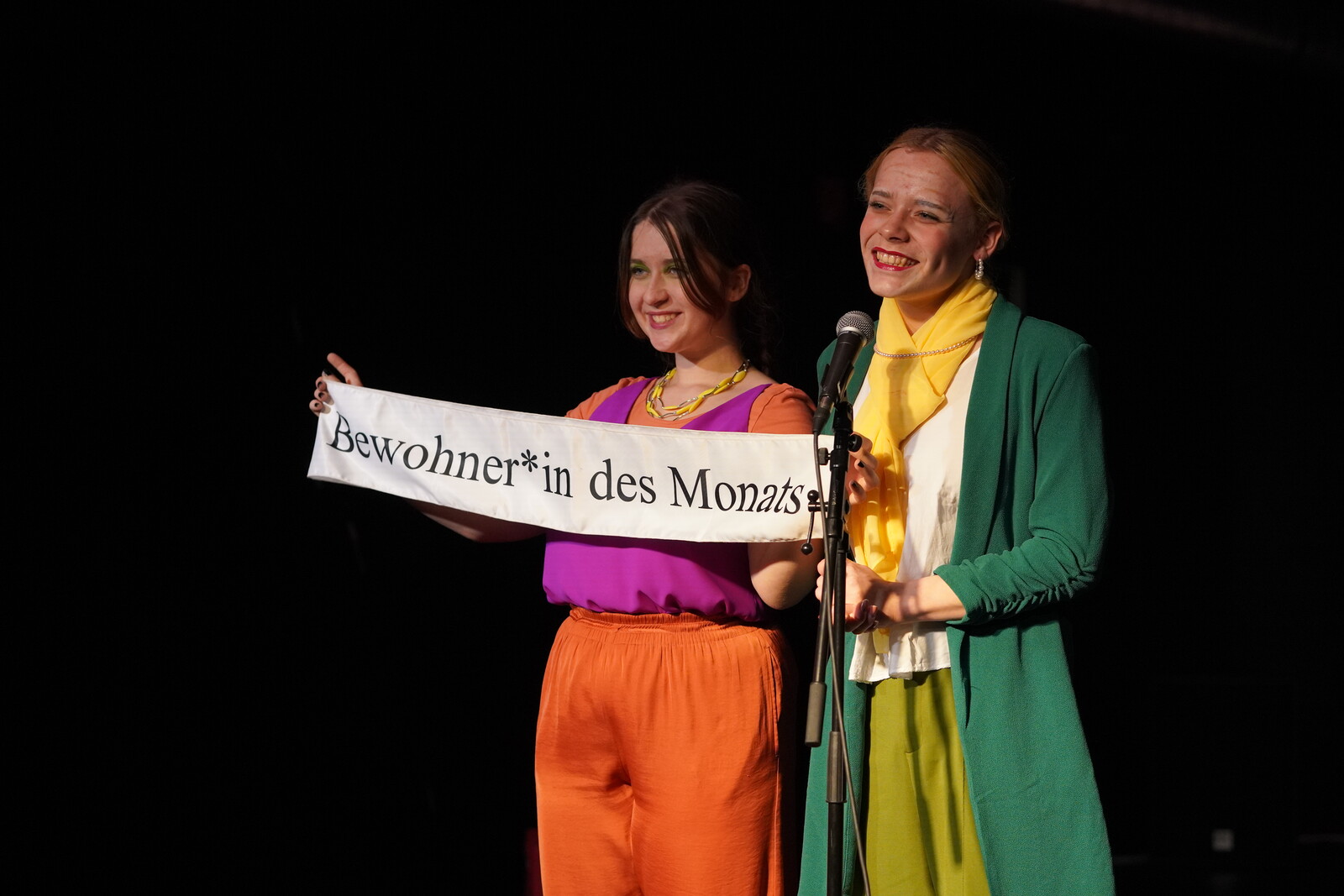 2 young adults with a sign