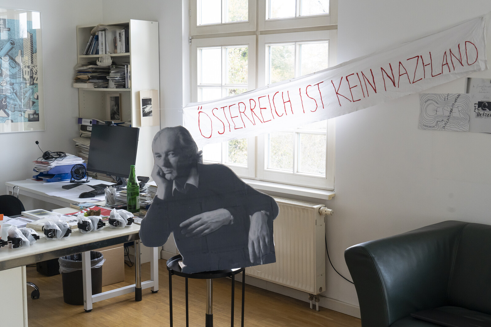 Ein Pappaufsteller mit dem Konterfei Thomas Bernhards auf einem Beistelltisch in einem Büro.