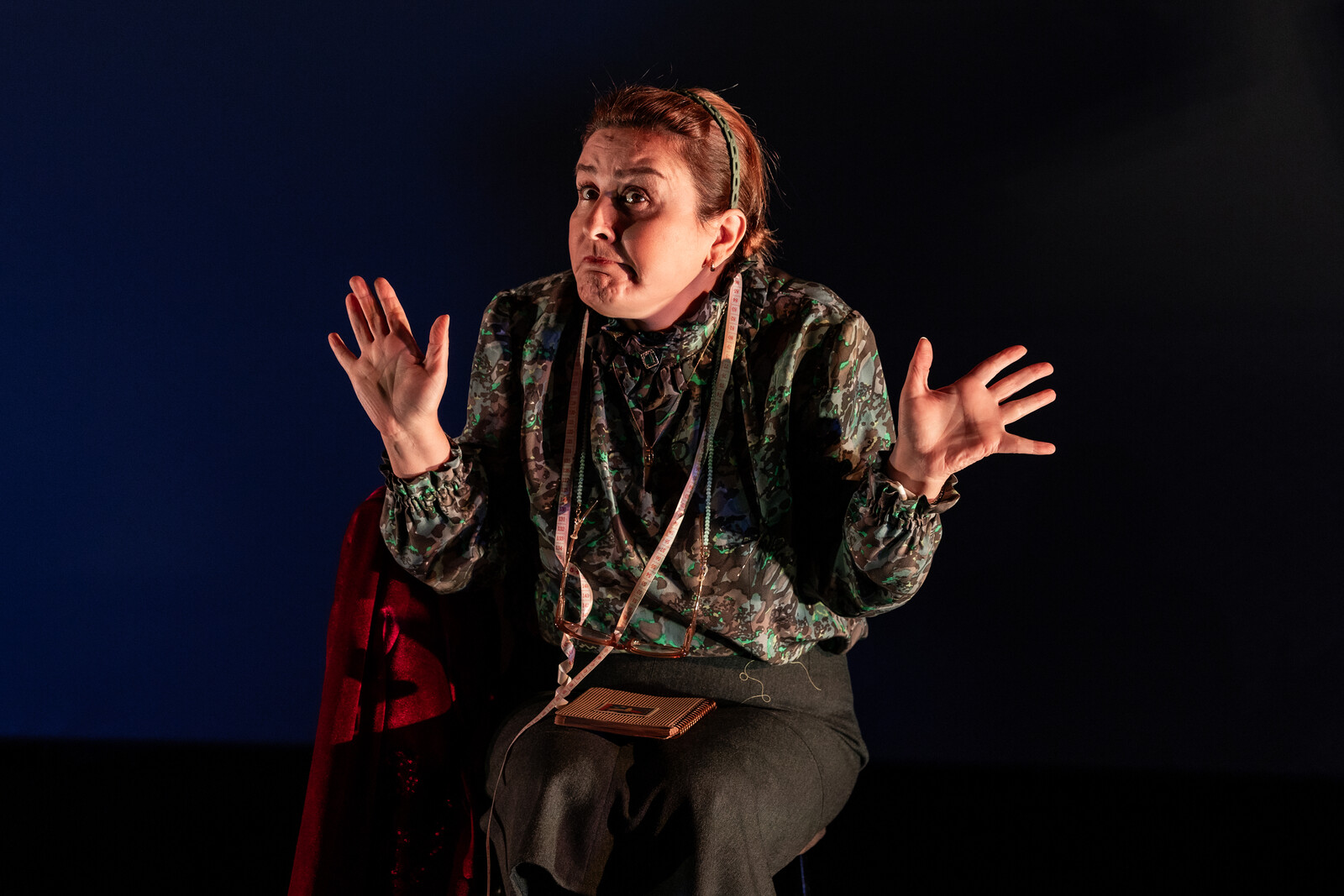 a women sits on a chair and does jazz hands, stretches her fingers