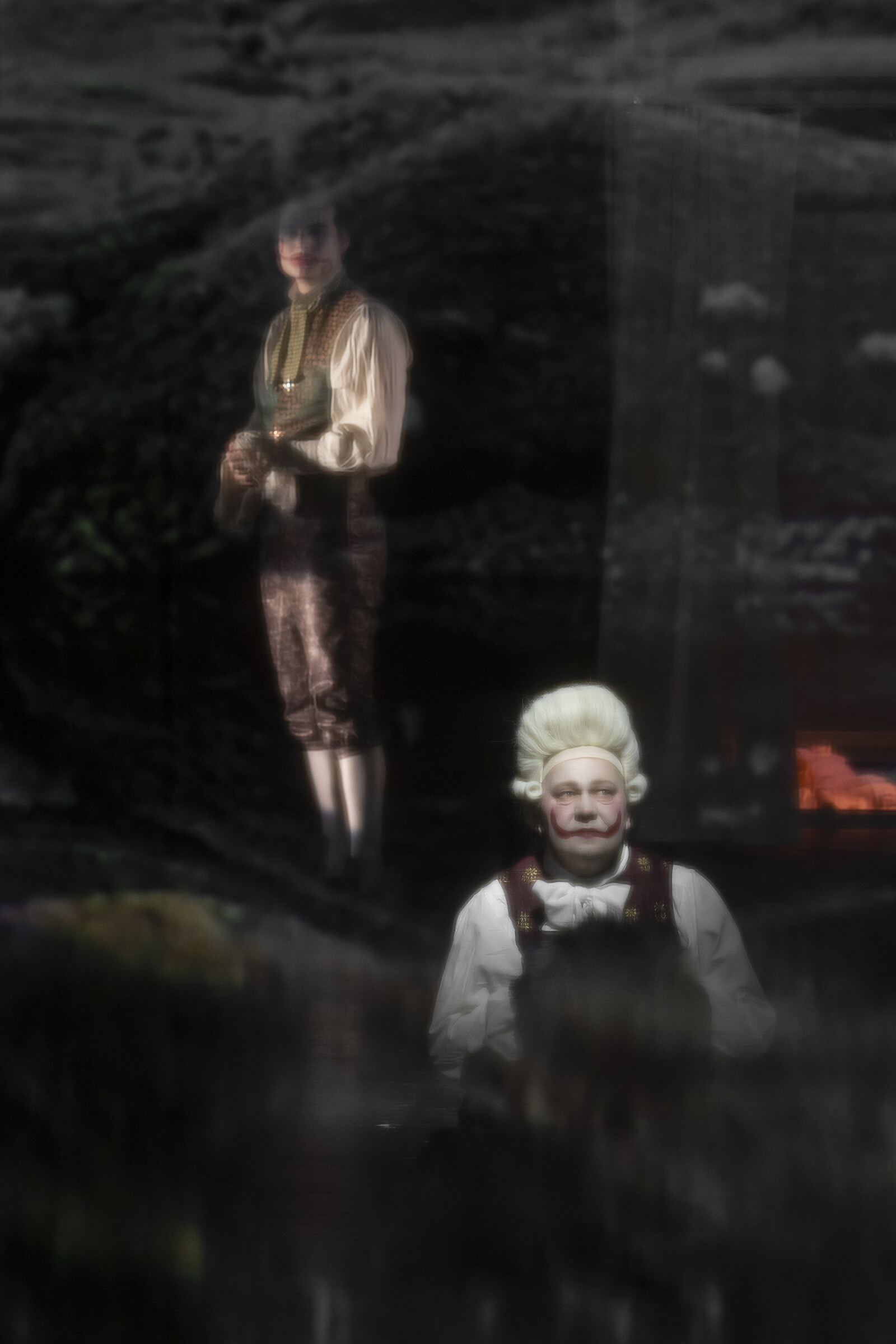 Zwei Darsteller hinter einer Gaze, auf die ein Bild projiziert ist.