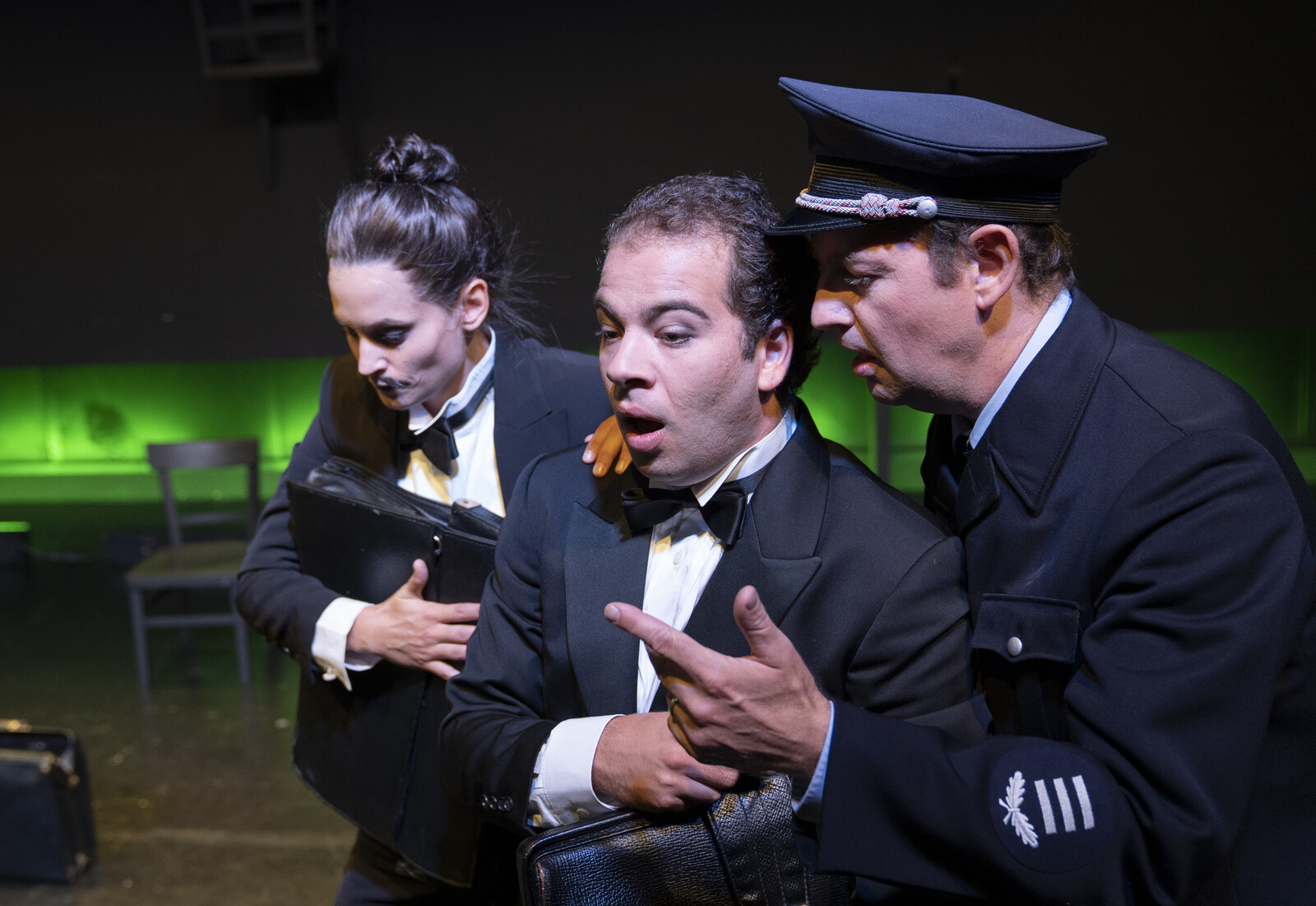 Three people, two wear suit, the other a uniform