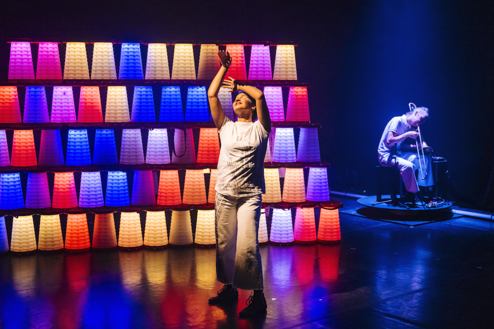 Actress dances in front of an illuminated wall