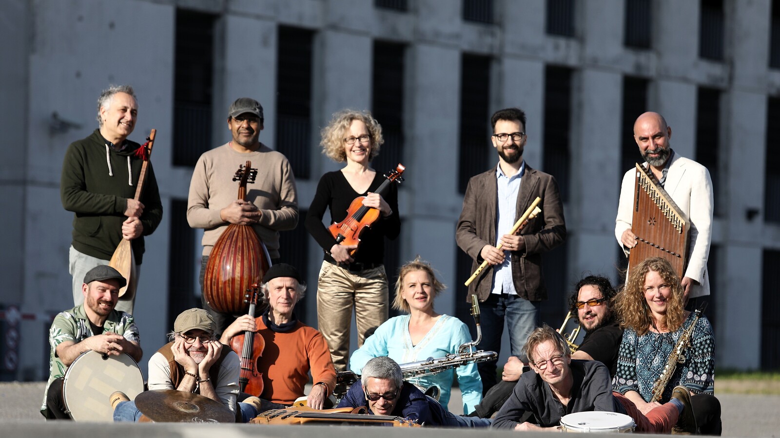 A diverse group of musicians with a variety of different international musical instruments.