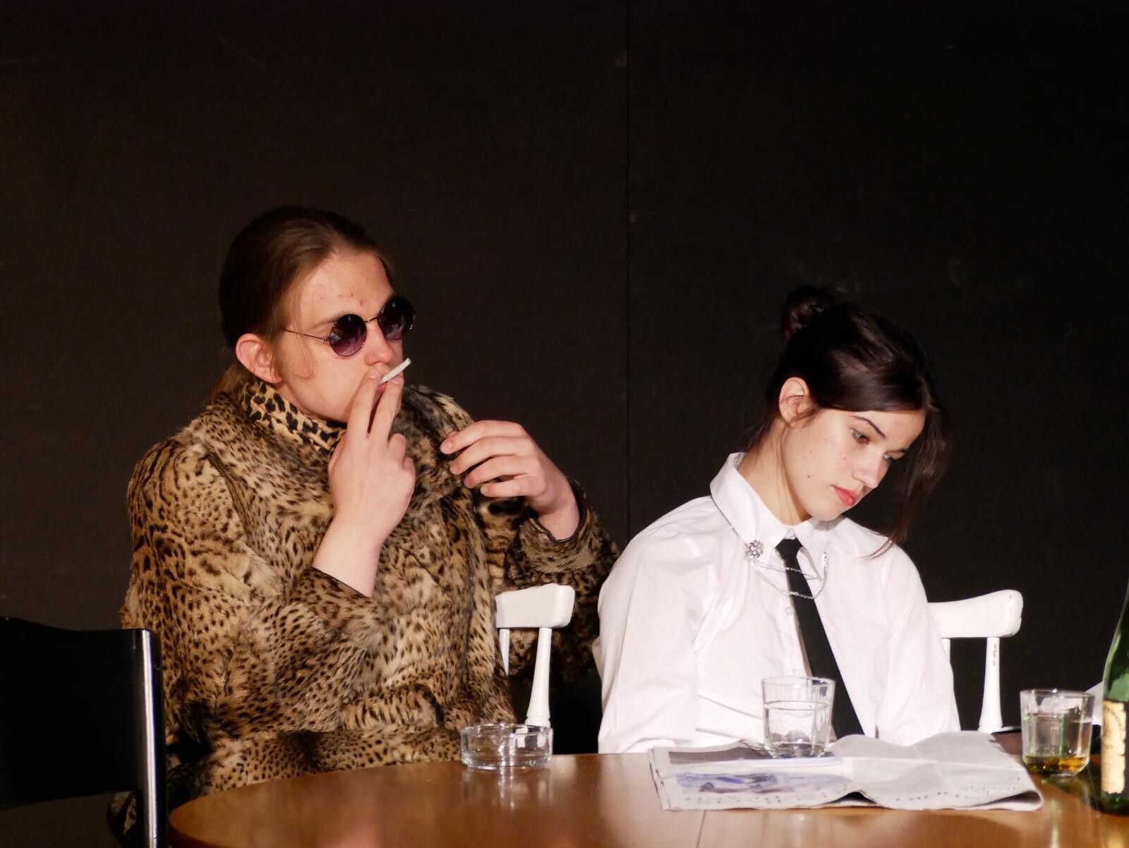 Two people on stage; two people sitting at a table