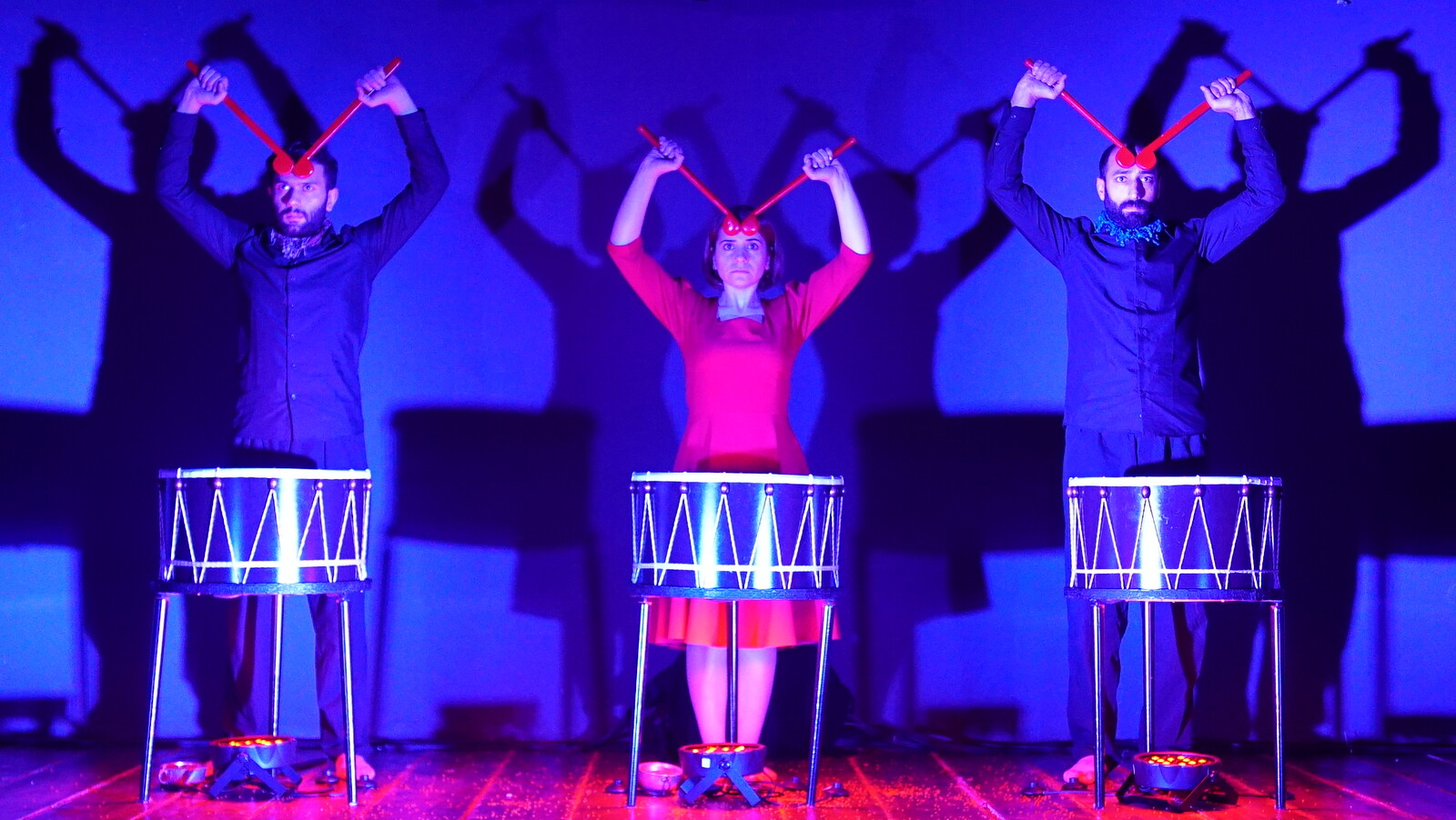 drei Menschen stehen und Trommeln